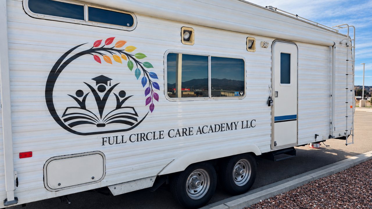 The Full Circle Care Academy mobile training lab, a white trailer with the Academy logo, parked with mountains in the distance.