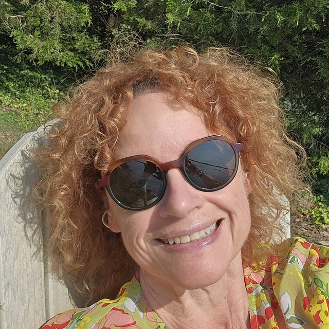 Pamela Long smiling outdoors in the sun, wearing sunglasses.