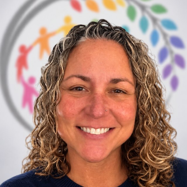 Victoria Falla smiling in front of the Full Circle logo.